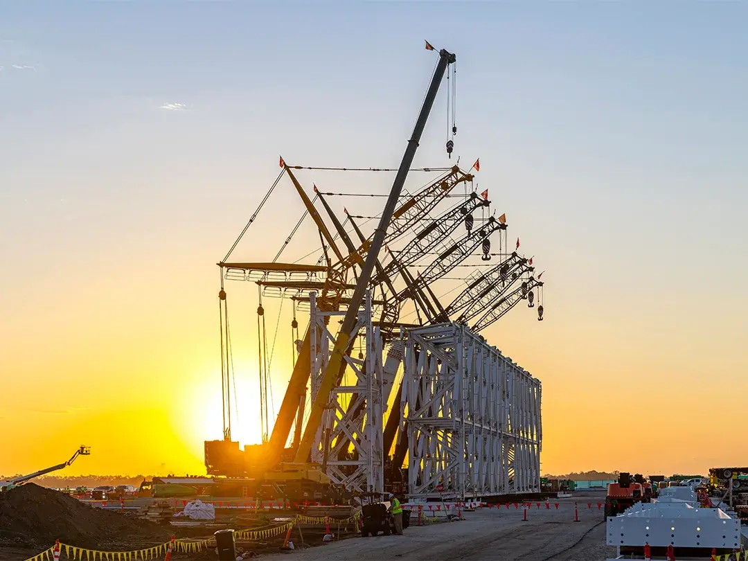 image of construction site lift of large truss structure by multiple cranes