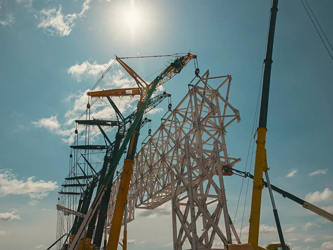 image of construction site lift of large truss structure by multiple cranes