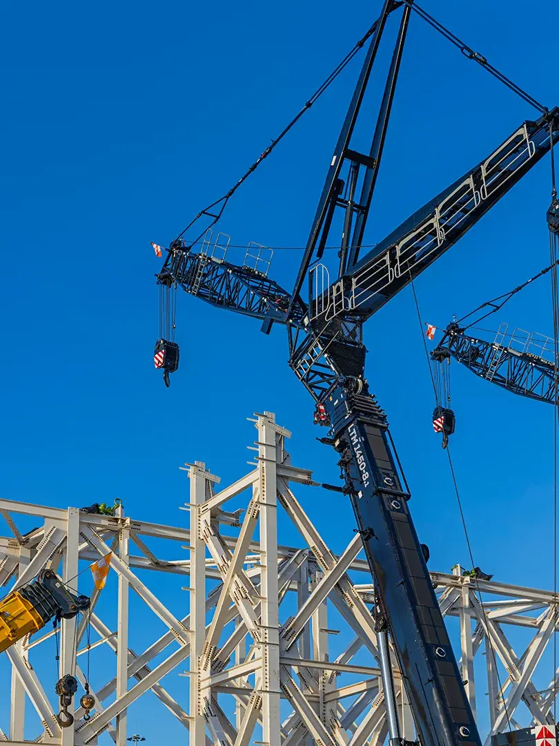 image of construction site lift of large truss structure by multiple cranes