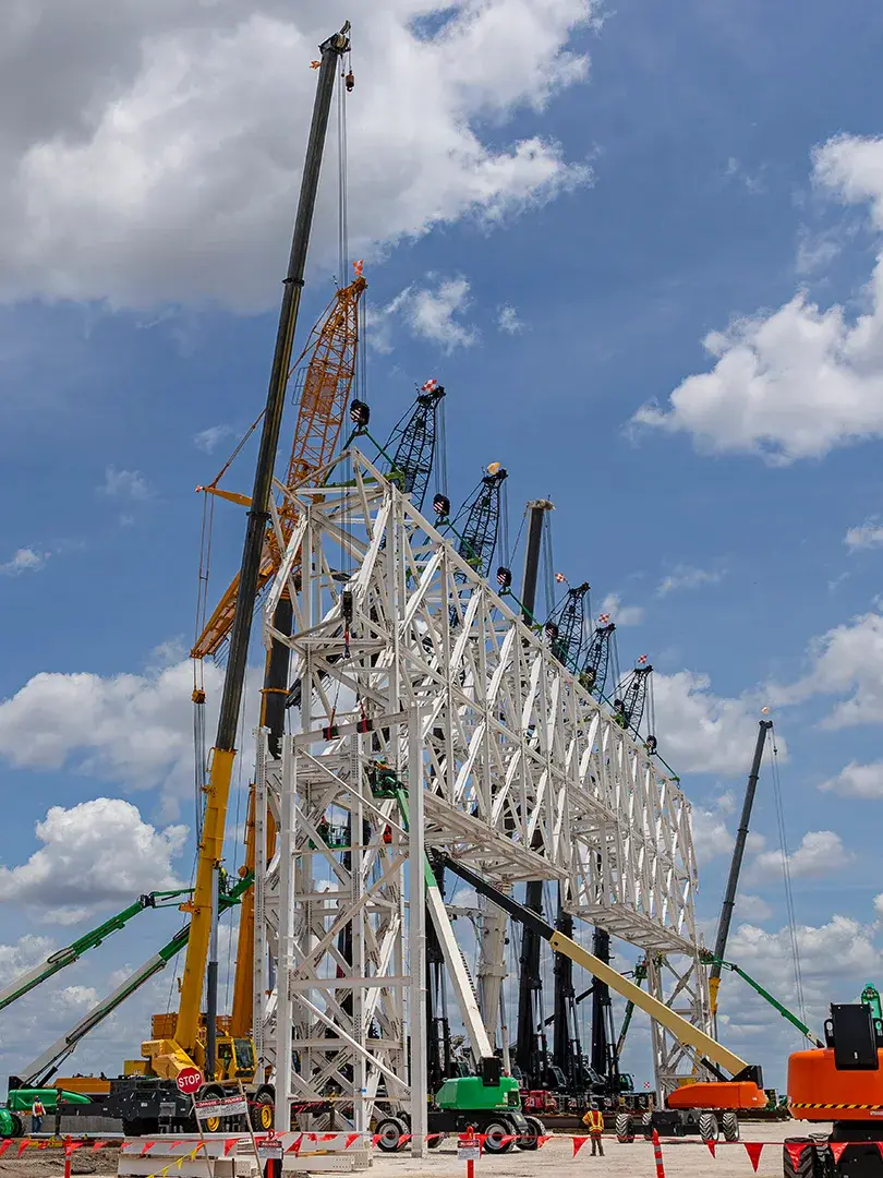 image of construction site lift of large truss structure by multiple cranes